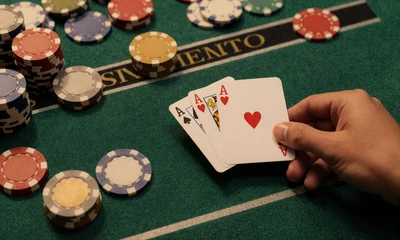 Blackjack-Hand mit Pik-Ass und Herz-K&ouml;nig auf gr&uuml;nem Filz mit Gold-Jetons